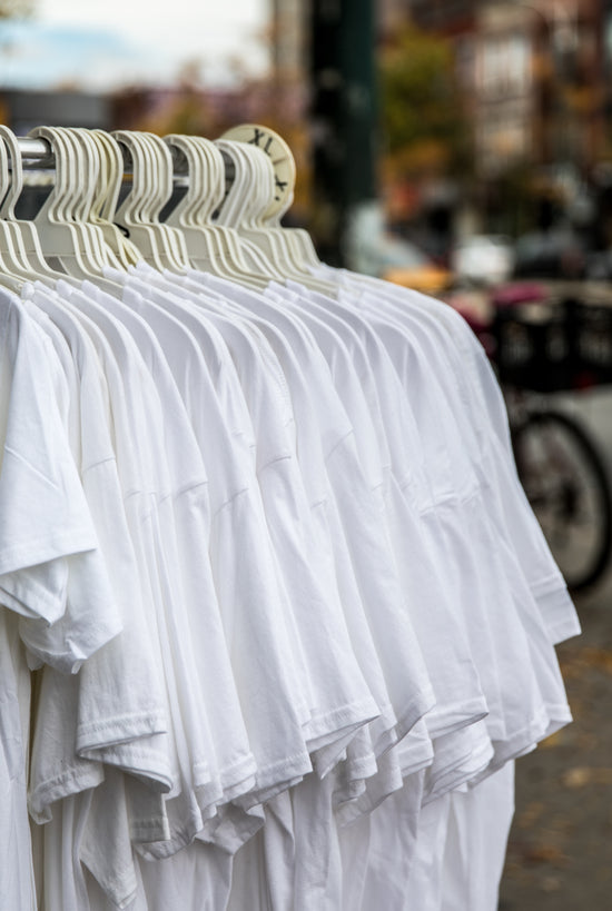 Image of Plain White T-Shirts Hanging on a Store Rack